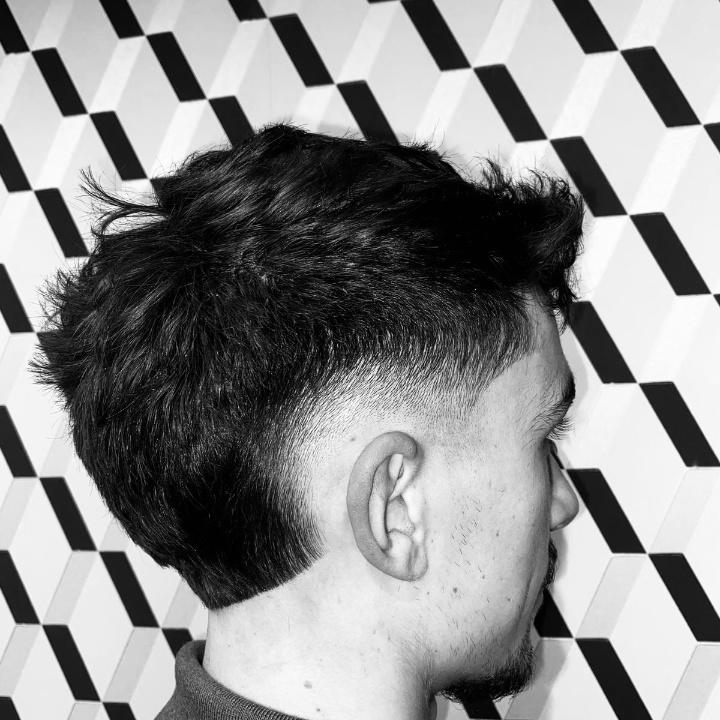Low Fade réalisé dans notre barbershop The Barber Company Auxerre. Un dégradé précis, net et maîtrisé par nos barbiers experts au Centre Commercial Auchan Fontaines des Clairions à Auxerre. Votre adresse pour les coupes homme, dégradés et tailles de barbe